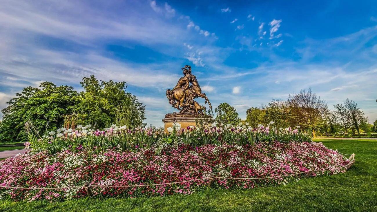 parc avec des fleurs et une statue